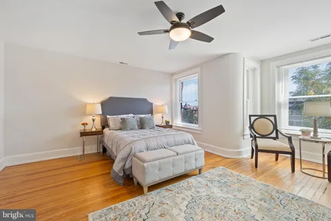 a bedroom with a bed lamps and a large mirror