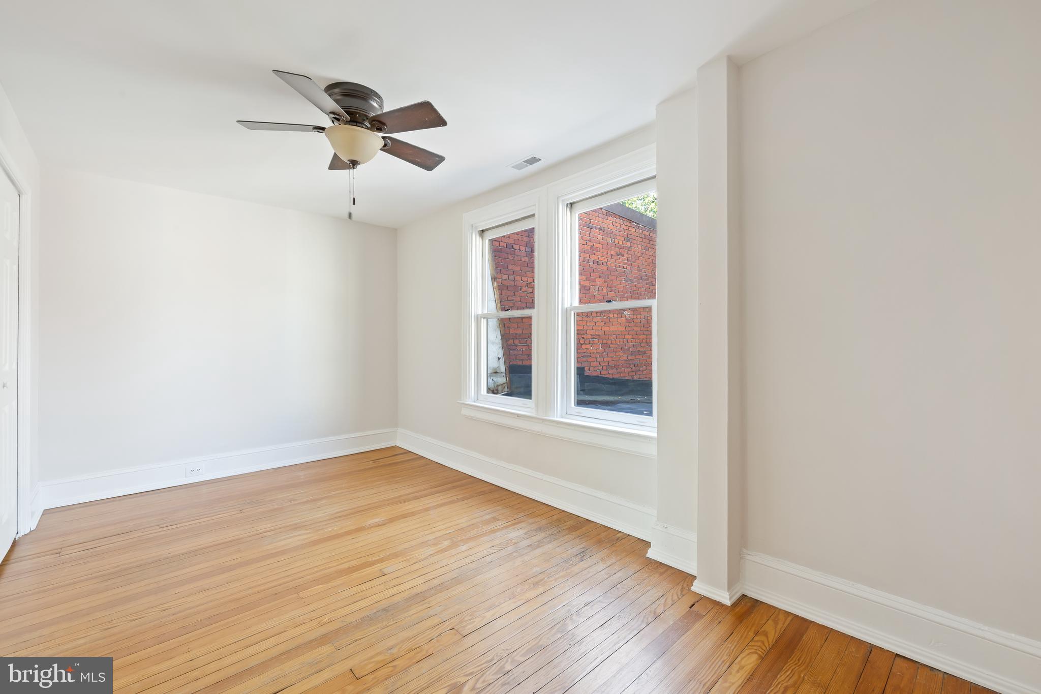 2724 13th Street Northwest Washington, DC 20009 - Photo 33 of 49 an empty room with wooden floor chandelier fan and windows