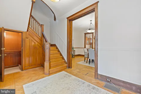 a view of a hallway with wooden floor and staircase
