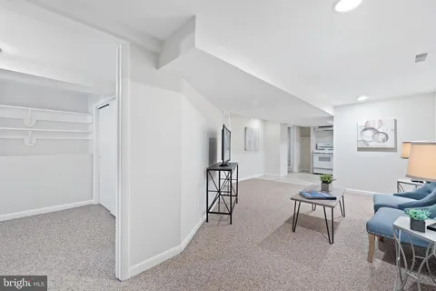 a view of an empty room with closet and a window