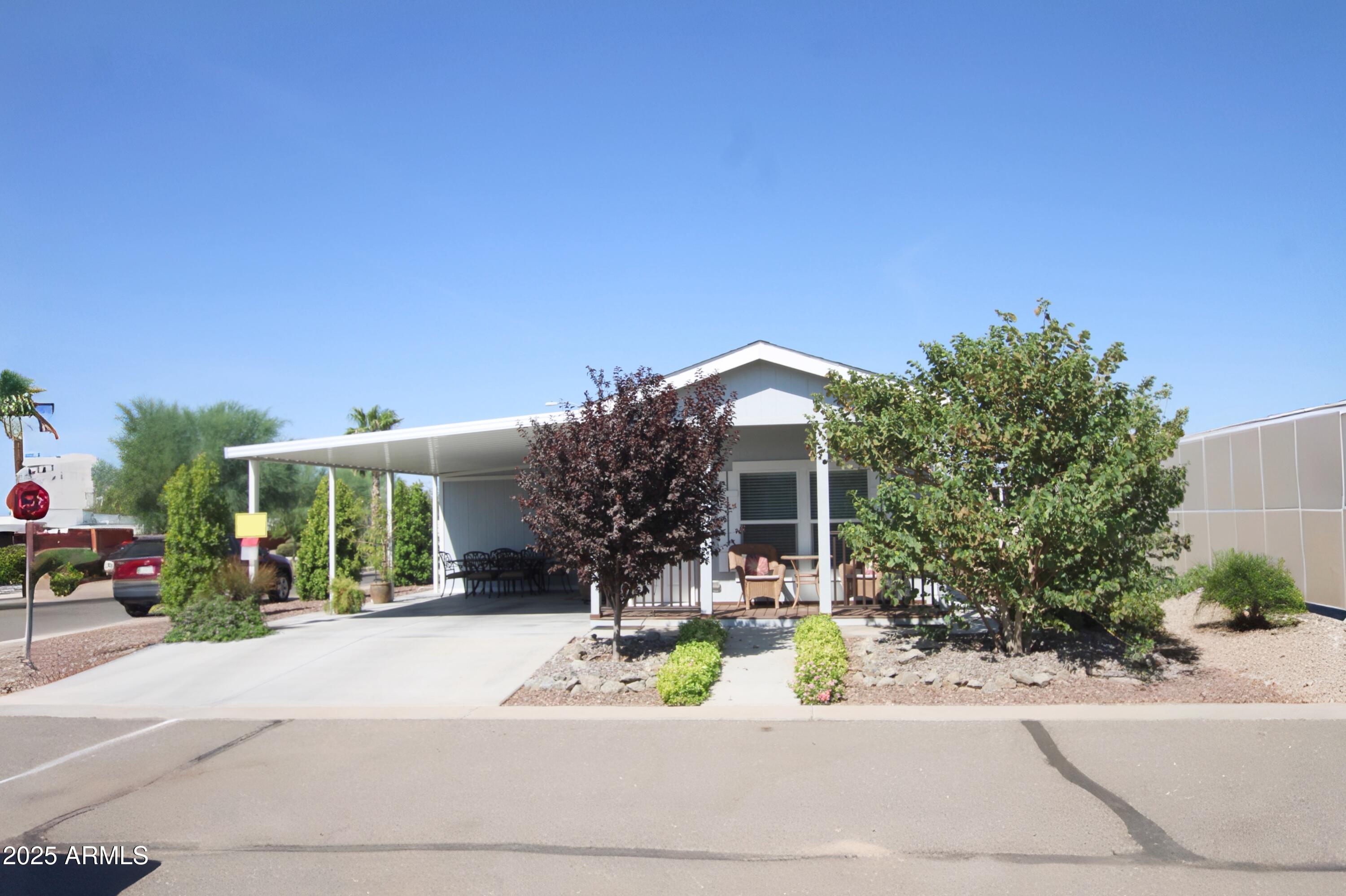 a front view of a house with a yard and potted plants