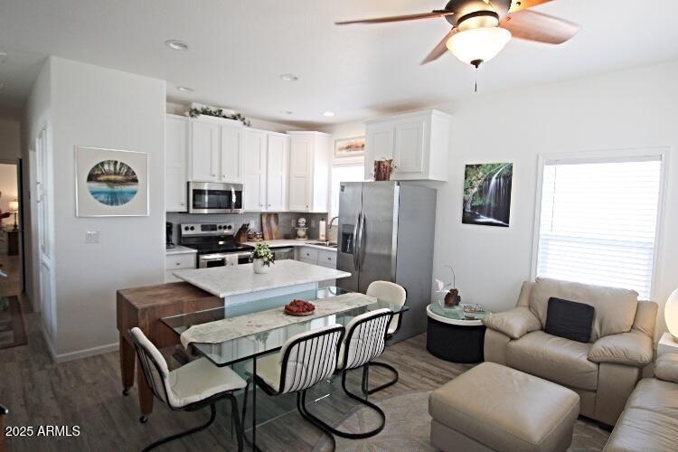 1837 North Thornton Road, Unit 45 Casa Grande, AZ 85122 - Photo 2 of 11 a kitchen with stainless steel appliances a dining table chairs refrigerator and sink