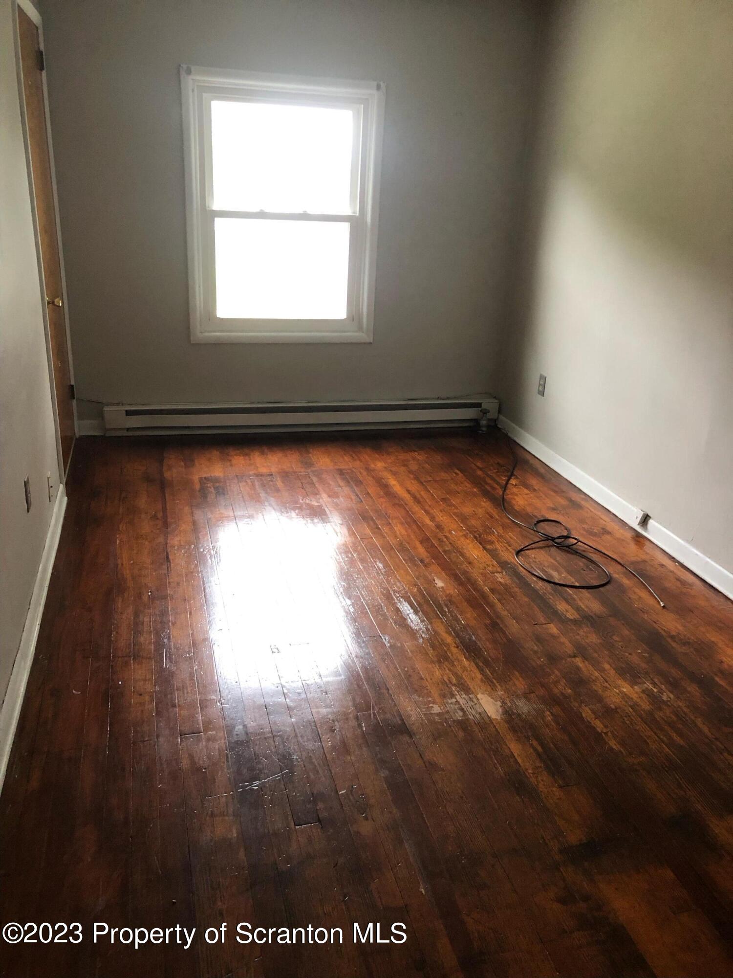 1111 Church Street Jessup, PA 18434 - Photo 7 of 10 an empty room with wooden floor and windows