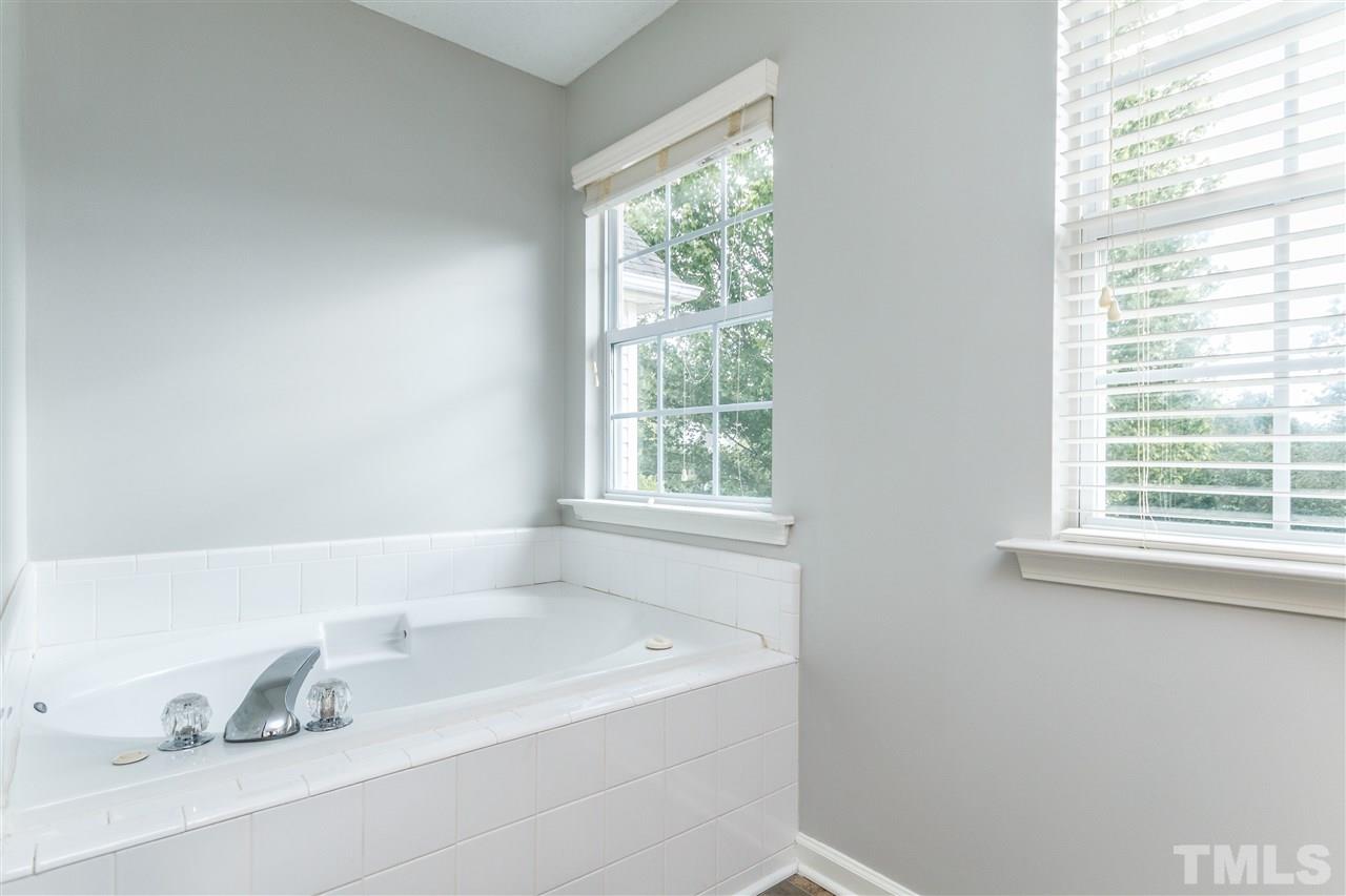 1035 Lake Moraine Place Raleigh, NC 27607 - Photo 11 of 19 a bathroom with a tub a window and a sink