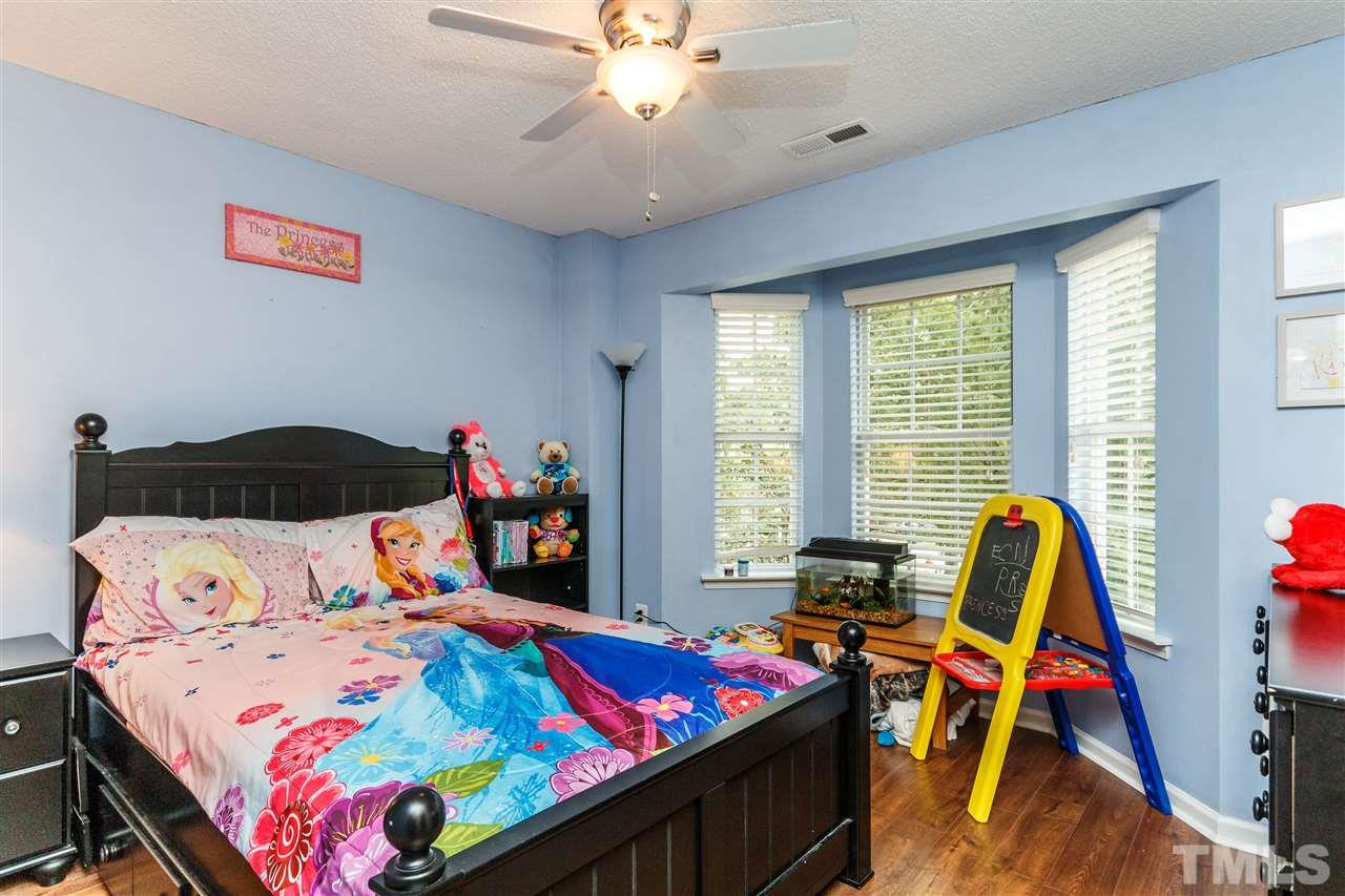 1035 Lake Moraine Place Raleigh, NC 27607 - Photo 15 of 19 a bedroom with a bed and a chandelier