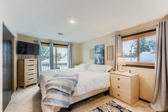 a bedroom with a bed and a large window