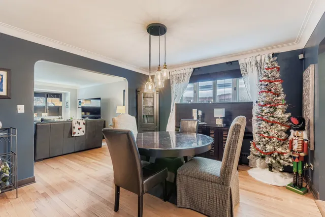 a dining room with furniture a chandelier and wooden floor