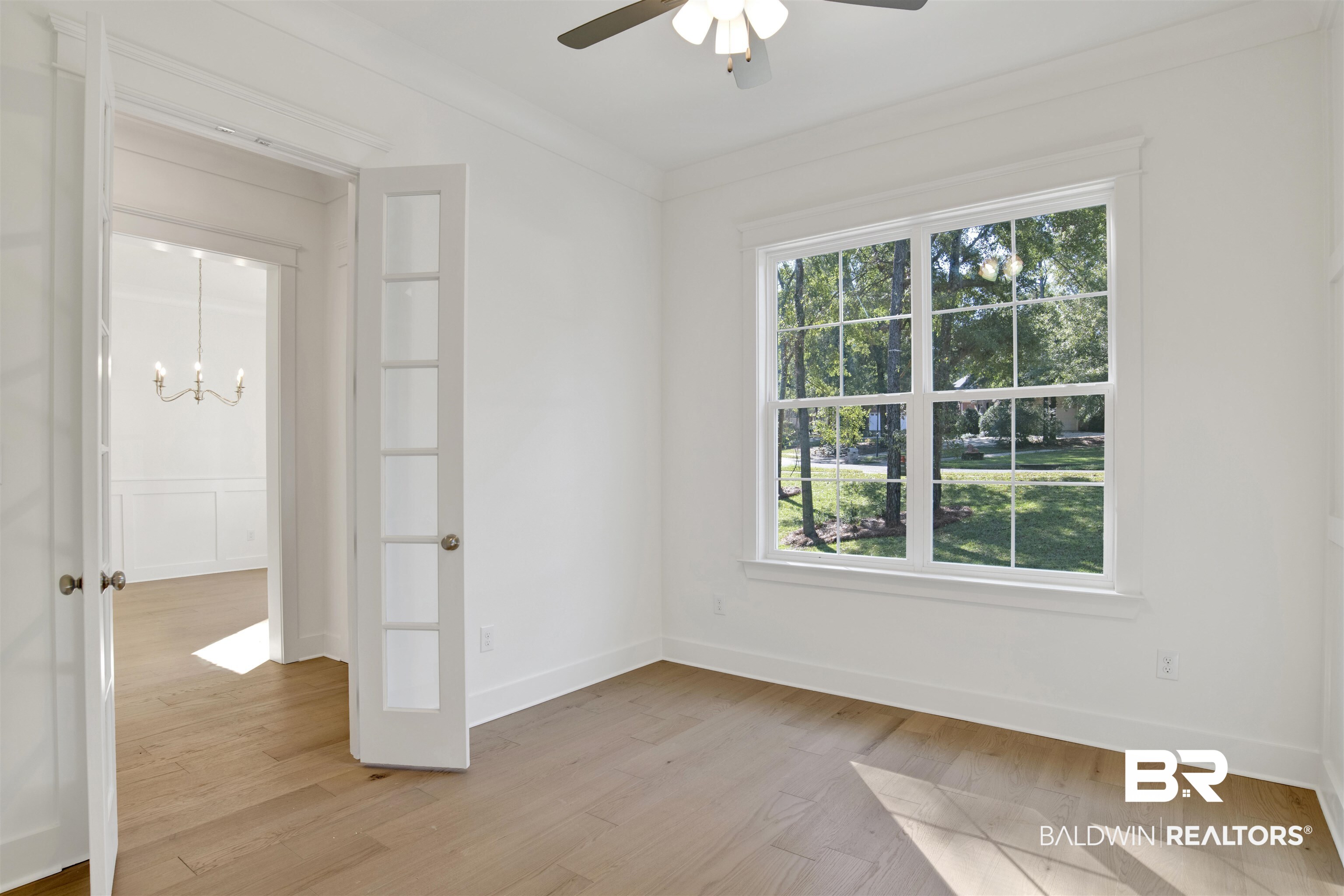 5 Long Leaf Circle Fairhope, AL 36532 - Photo 19 of 44 Unfurnished room with light hardwood / wood-style flooring, a healthy amount of sunlight, ceiling fan with notable chandelier, and ornamental molding