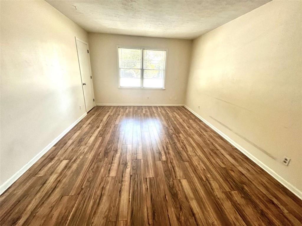 1002 Level Creek Road, Unit 201 Sugar Hill, GA 30518 - Photo 5 of 13 an empty room with wooden floor and windows