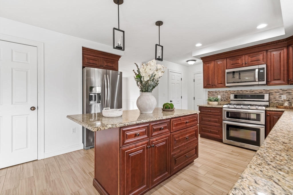 30 Neponset Street Walpole, MA 02071 - Photo 21 of 41 a kitchen with stainless steel appliances kitchen island granite countertop a stove a sink and a wooden floors