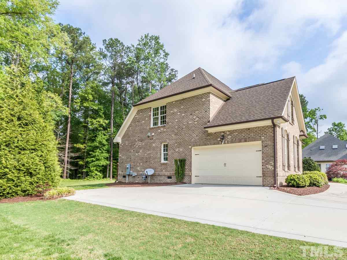 3424 Griffice Mill Road Raleigh, NC 27610 - Photo 24 of 25 a front view of a house with a garden and garage