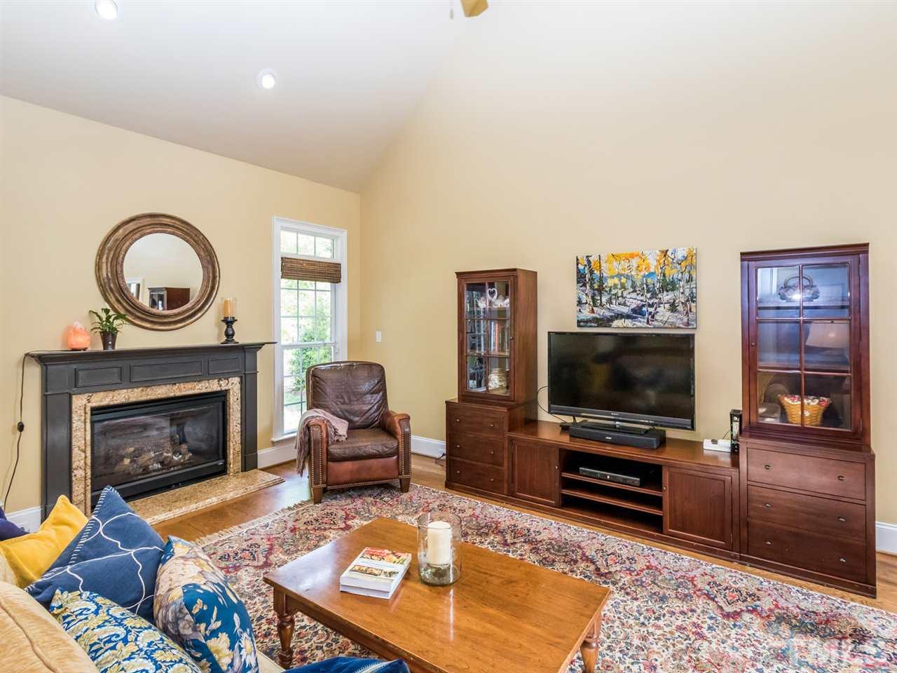 3424 Griffice Mill Road Raleigh, NC 27610 - Photo 4 of 25 a living room with furniture a flat screen tv and a fireplace