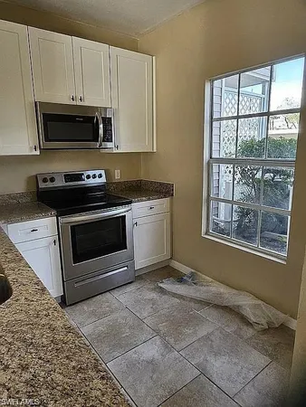 a kitchen with granite countertop a stove a microwave and a sink