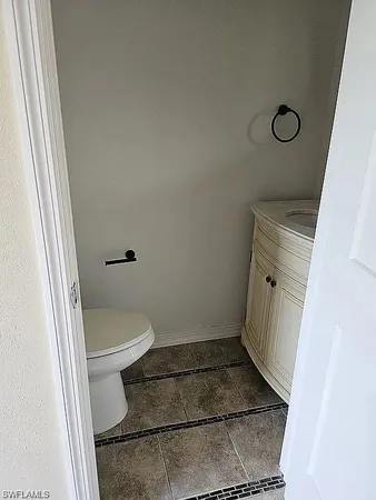 a bathroom with a granite countertop toilet and a sink