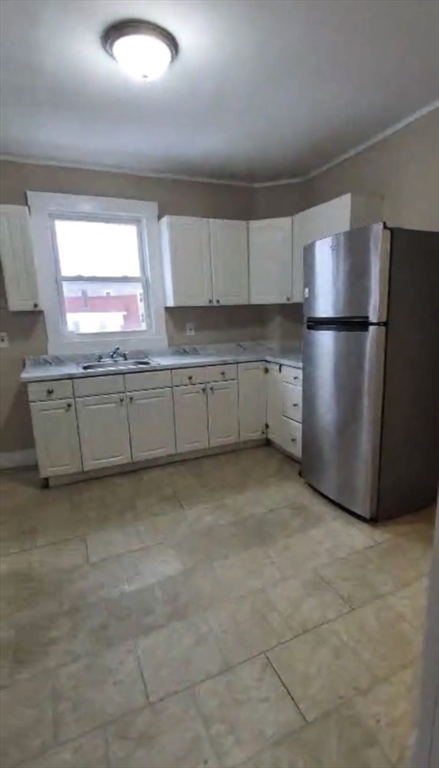 279 Chestnut Street, Unit 2 Lynn, MA 01902 - Photo 2 of 13 a kitchen with a refrigerator and window