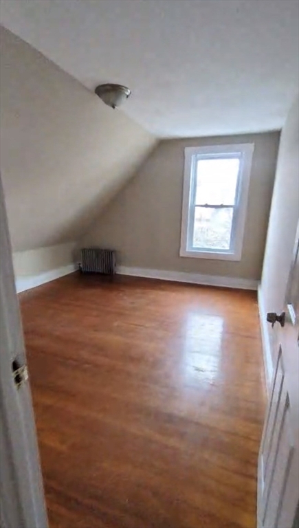 279 Chestnut Street, Unit 2 Lynn, MA 01902 - Photo 6 of 13 an empty room with wooden floor and windows