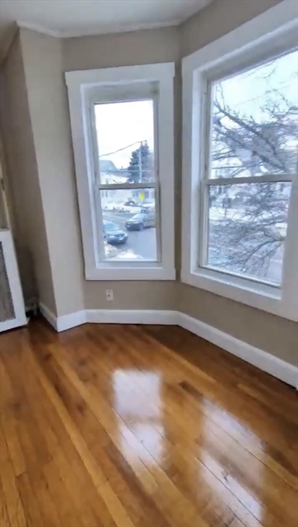 279 Chestnut Street, Unit 2 Lynn, MA 01902 - Photo 10 of 13 a view of an empty room with wooden floor and a window