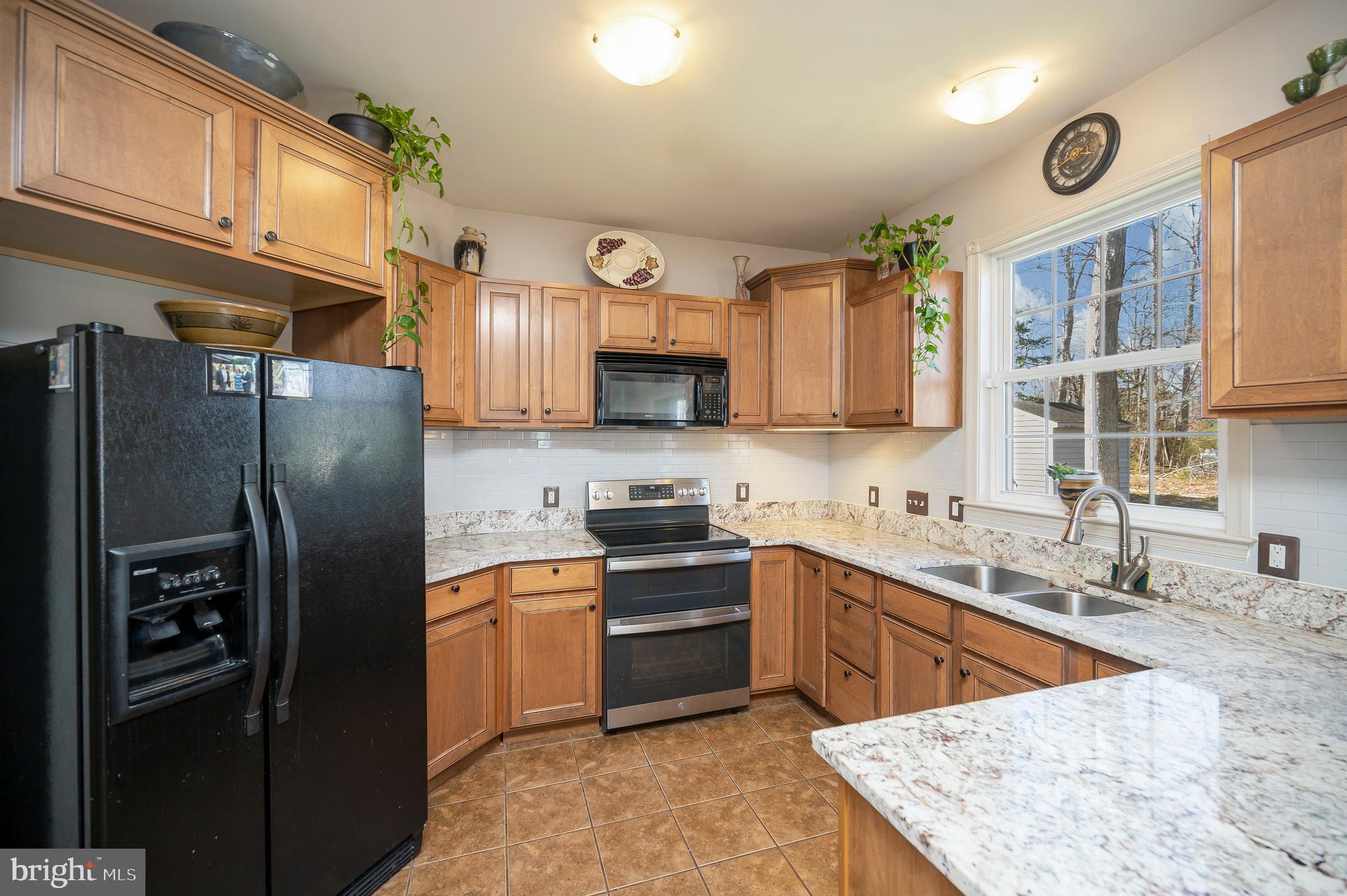 408 Liberty Boulevard Locust Grove, VA 22508 - Photo 6 of 45 a kitchen with stainless steel appliances granite countertop a refrigerator a sink a stove a microwave and island