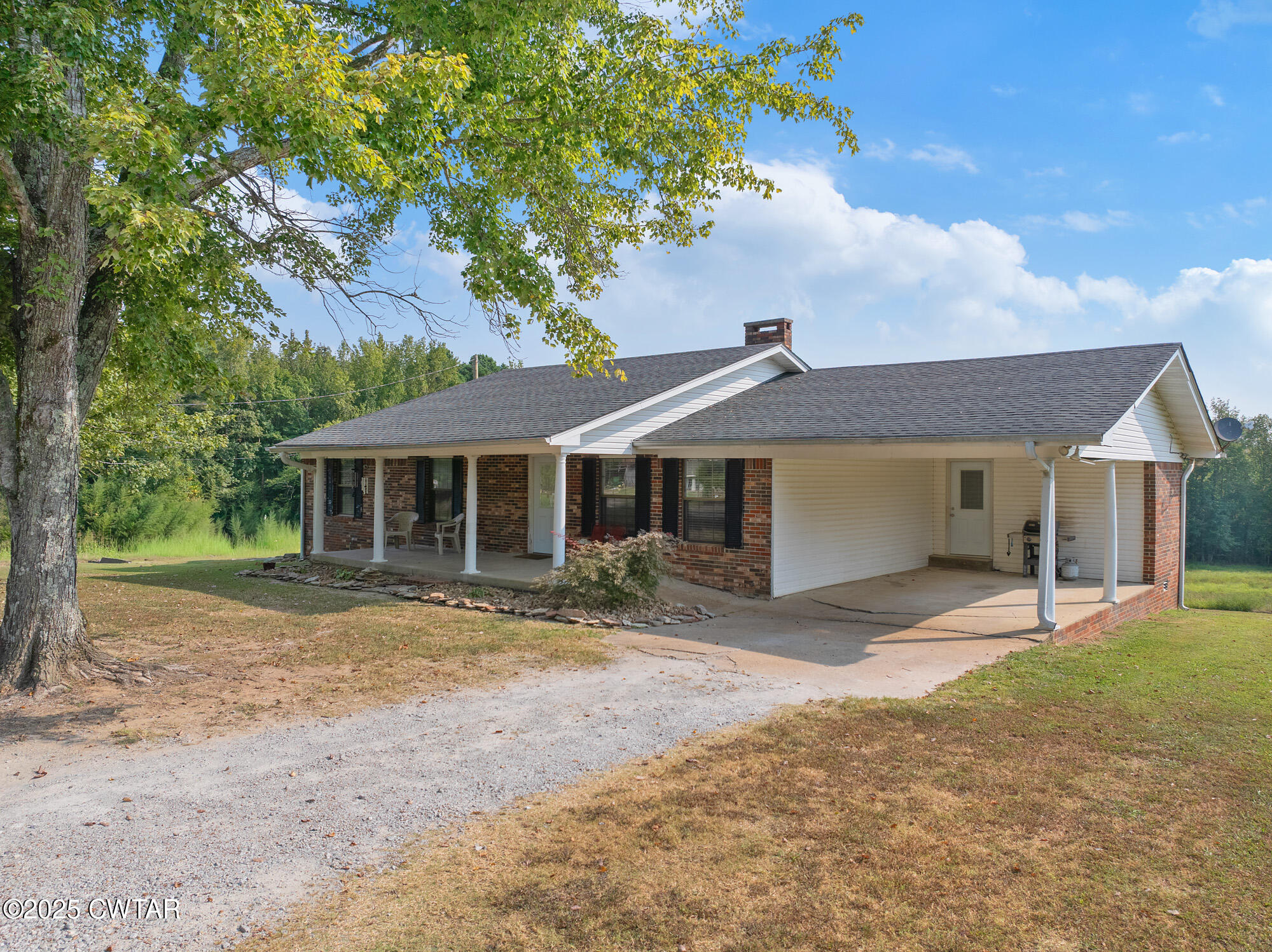 1176 Myracle Town Road Darden, TN 38328 - Photo 4 of 40 a front view of a house with a yard and garage