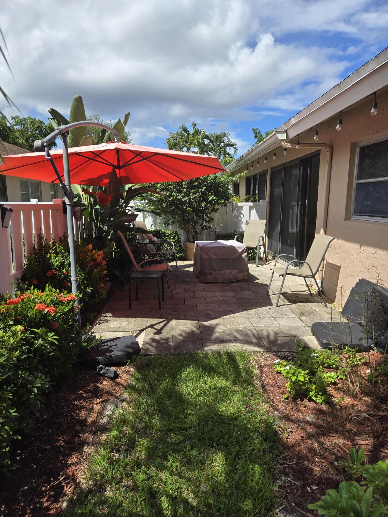 8081 Springtree Road, Unit C Boca Raton, FL 33496 - Photo 13 of 31 a view of a house with backyard sitting area and garden