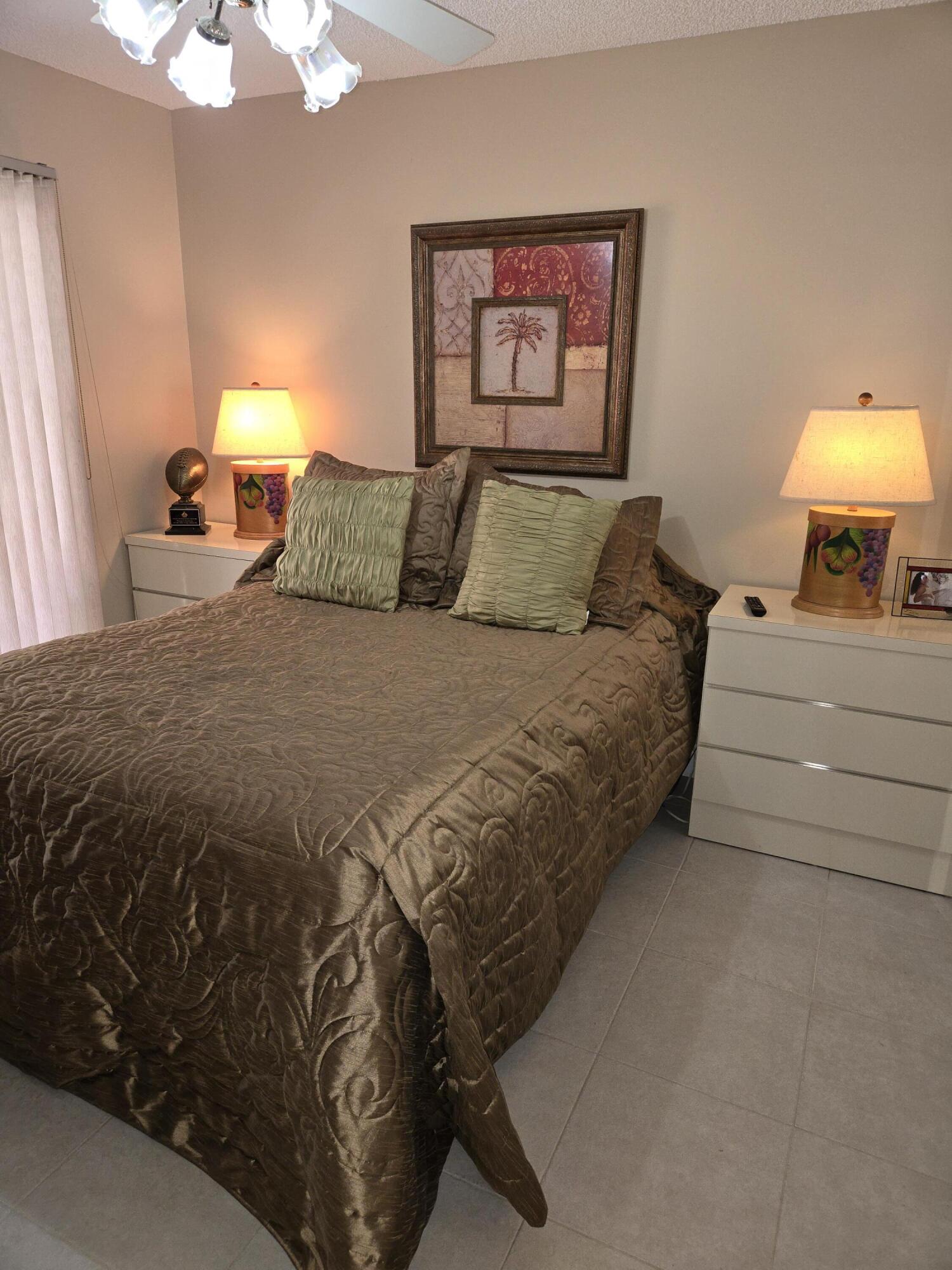 8081 Springtree Road, Unit C Boca Raton, FL 33496 - Photo 16 of 31 a bedroom with a bed and a lamp on dresser