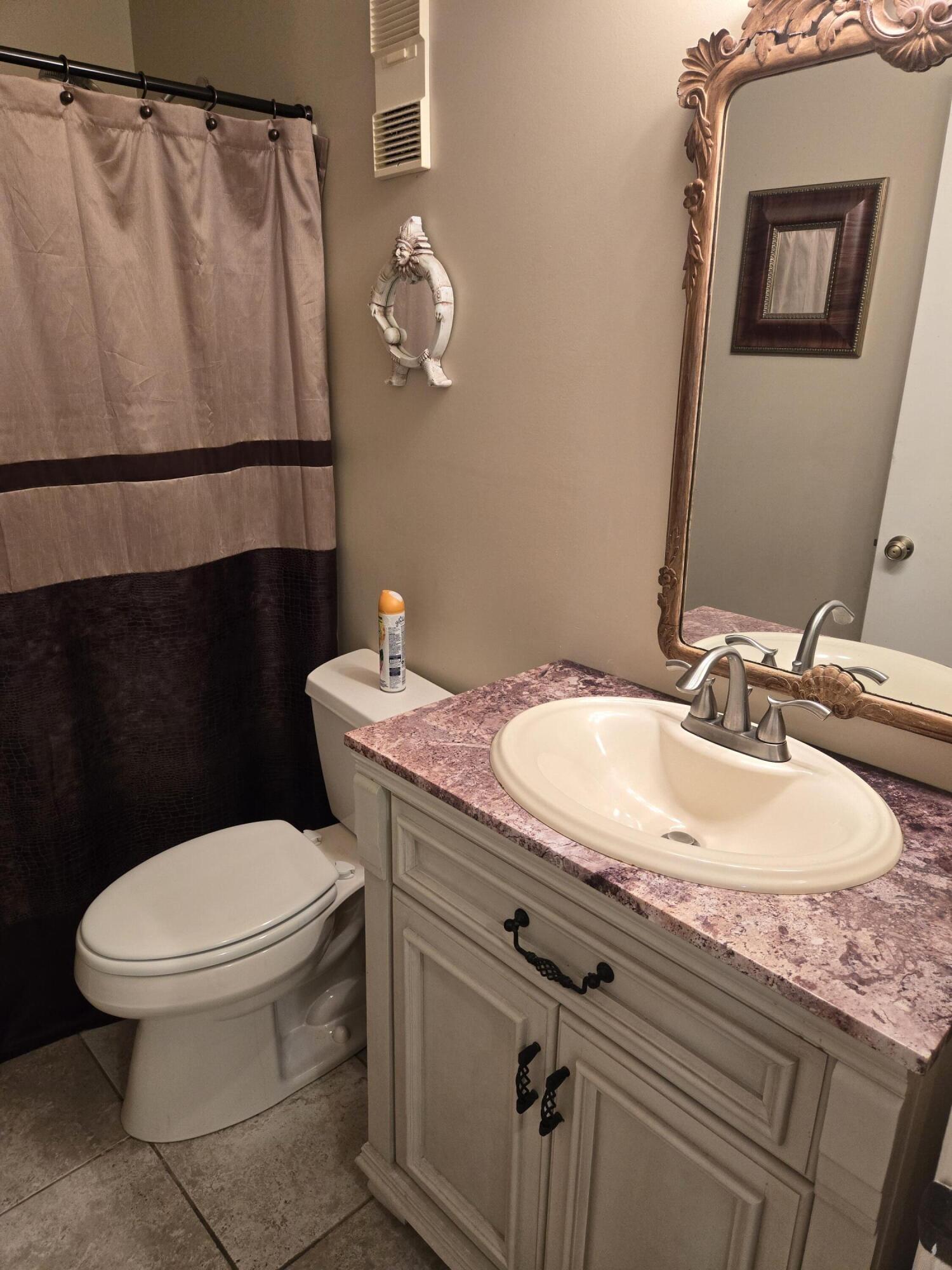 8081 Springtree Road, Unit C Boca Raton, FL 33496 - Photo 18 of 31 a bathroom with a granite countertop toilet sink and mirror