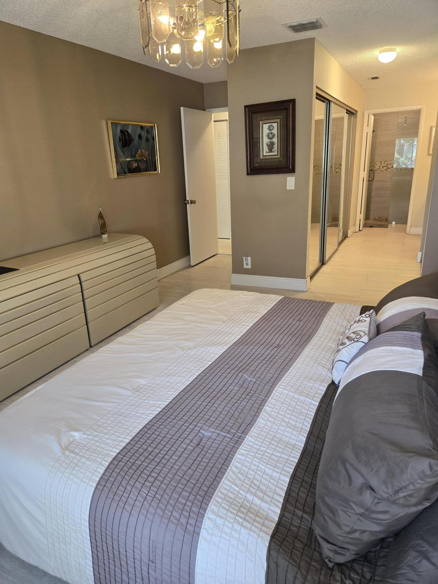 8081 Springtree Road, Unit C Boca Raton, FL 33496 - Photo 20 of 31 a bedroom with a bed and a couch