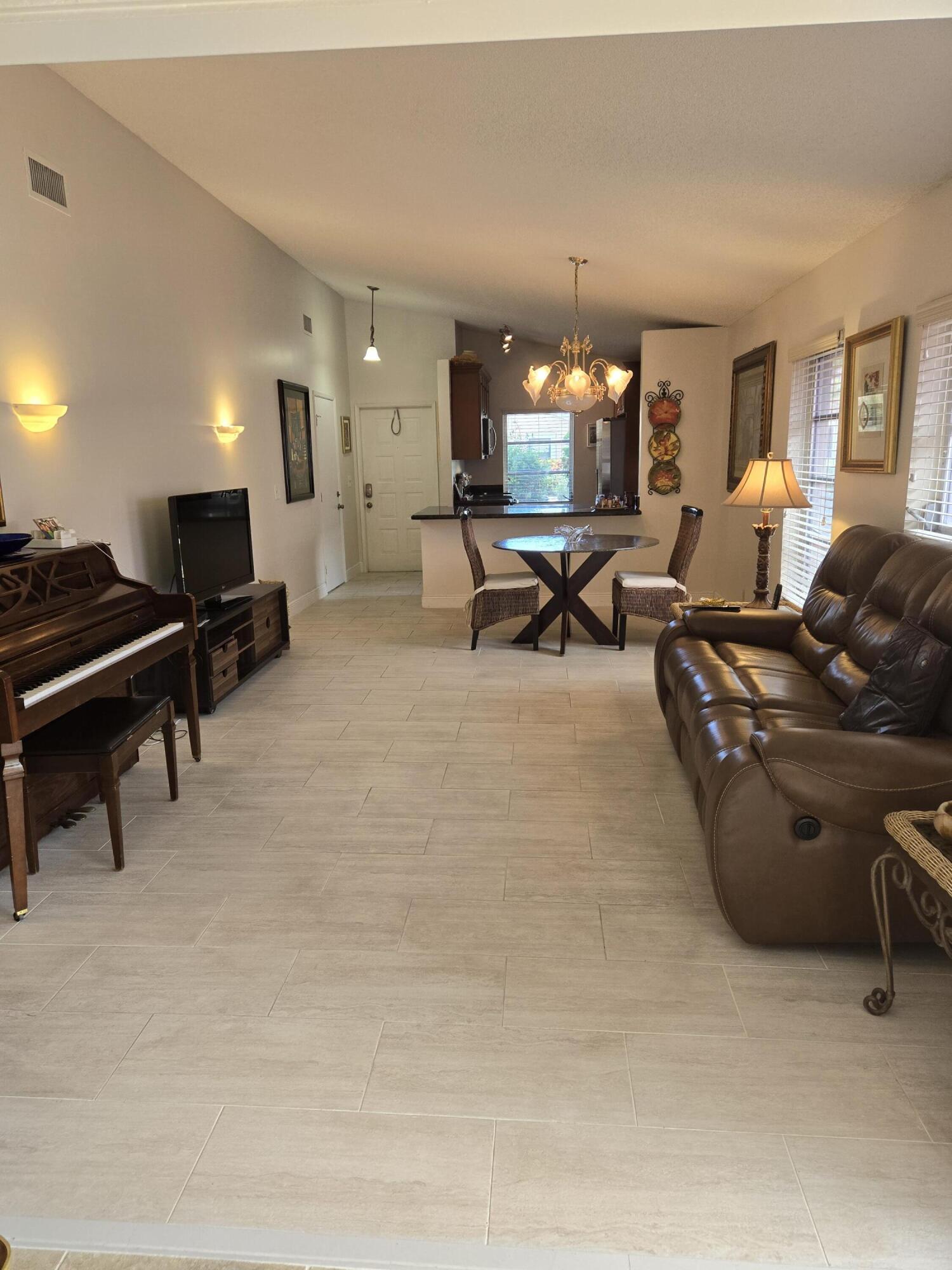 8081 Springtree Road, Unit C Boca Raton, FL 33496 - Photo 2 of 31 a living room with furniture and a potted plant