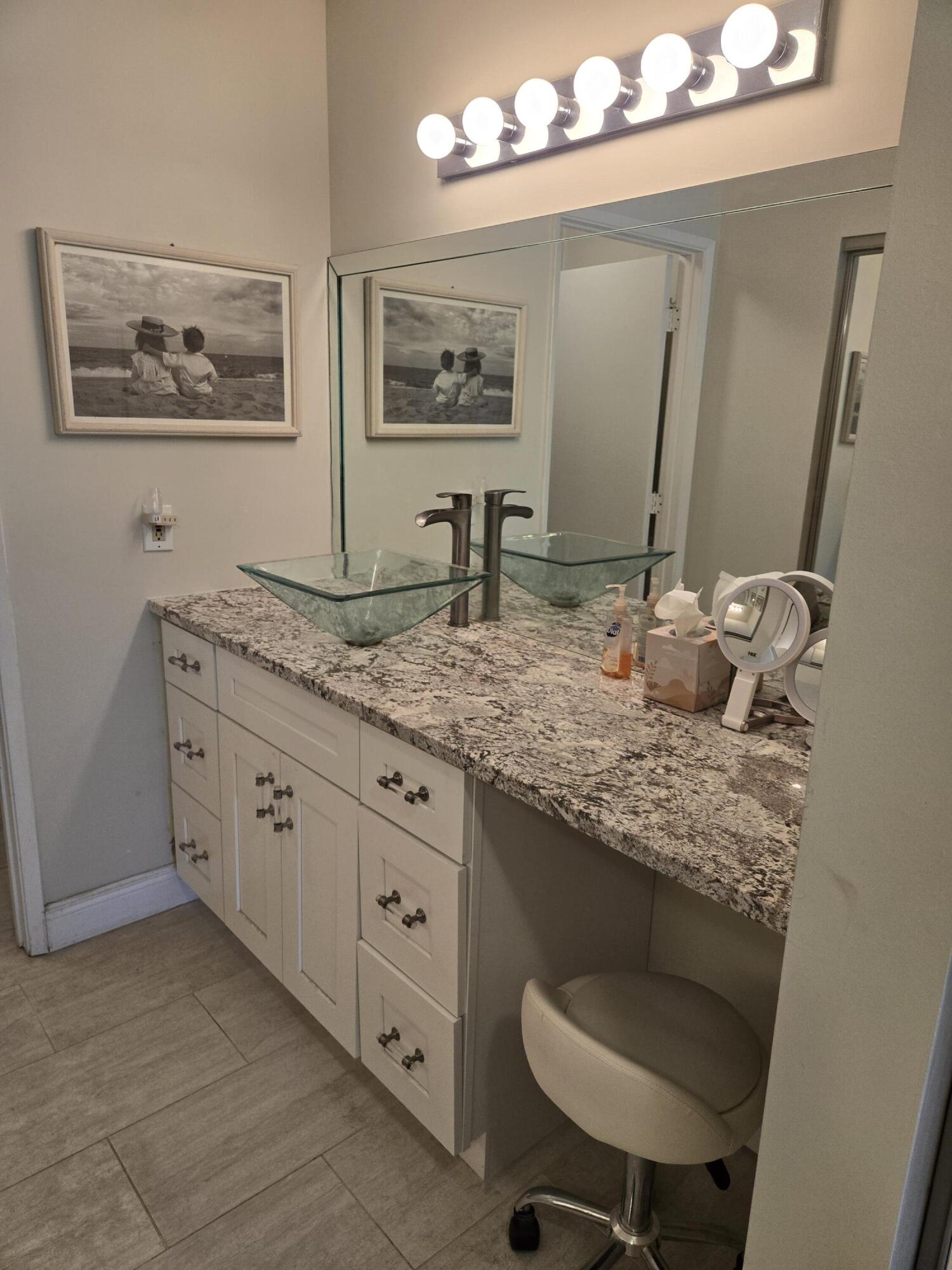 8081 Springtree Road, Unit C Boca Raton, FL 33496 - Photo 24 of 31 a bathroom with a granite countertop sink a toilet and mirror