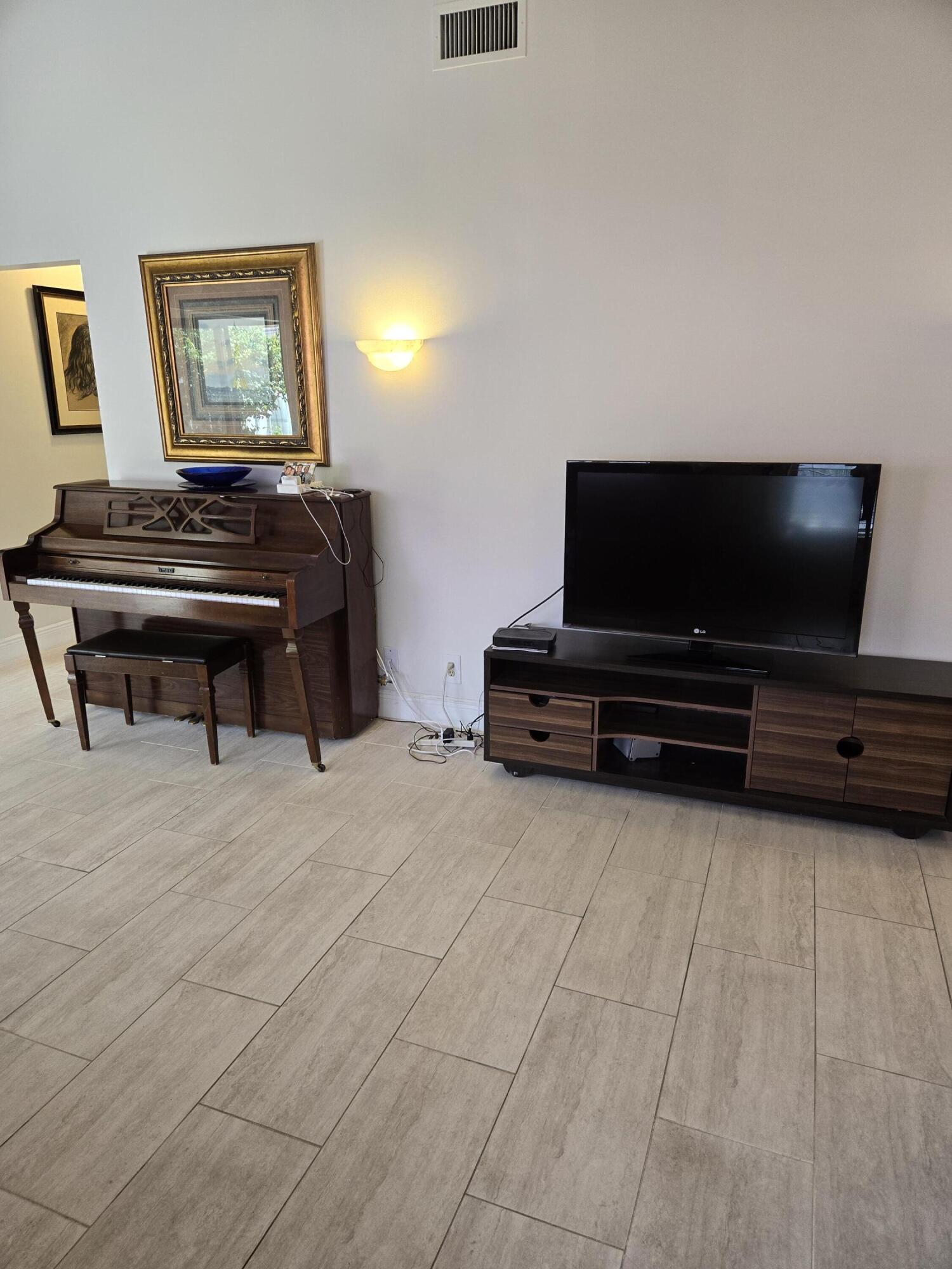 8081 Springtree Road, Unit C Boca Raton, FL 33496 - Photo 5 of 31 a living room with furniture and a flat screen tv