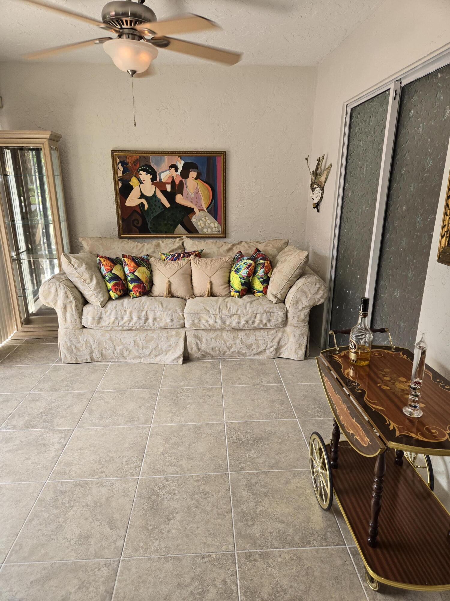 8081 Springtree Road, Unit C Boca Raton, FL 33496 - Photo 6 of 31 a living room with furniture a flat screen tv and a fireplace