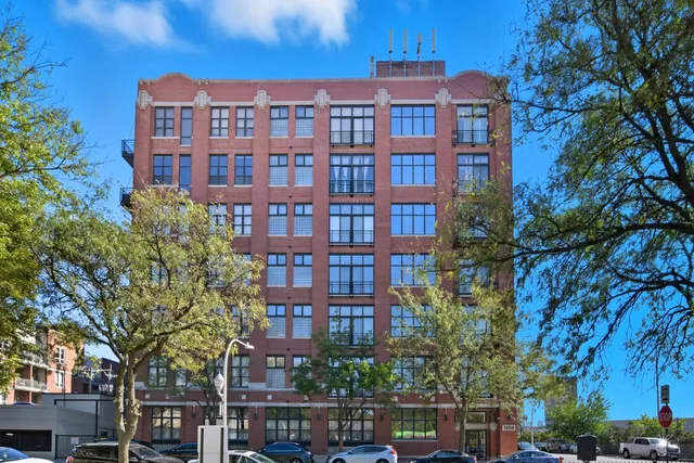 a front view of a multi story building with a yard