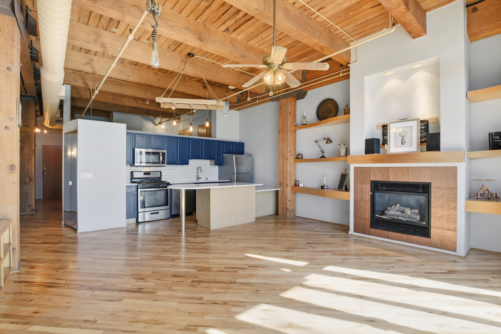 1250 West Van Buren Street, Unit 313 Chicago, IL 60607 - Photo 3 of 16 a living room with furniture and a fireplace
