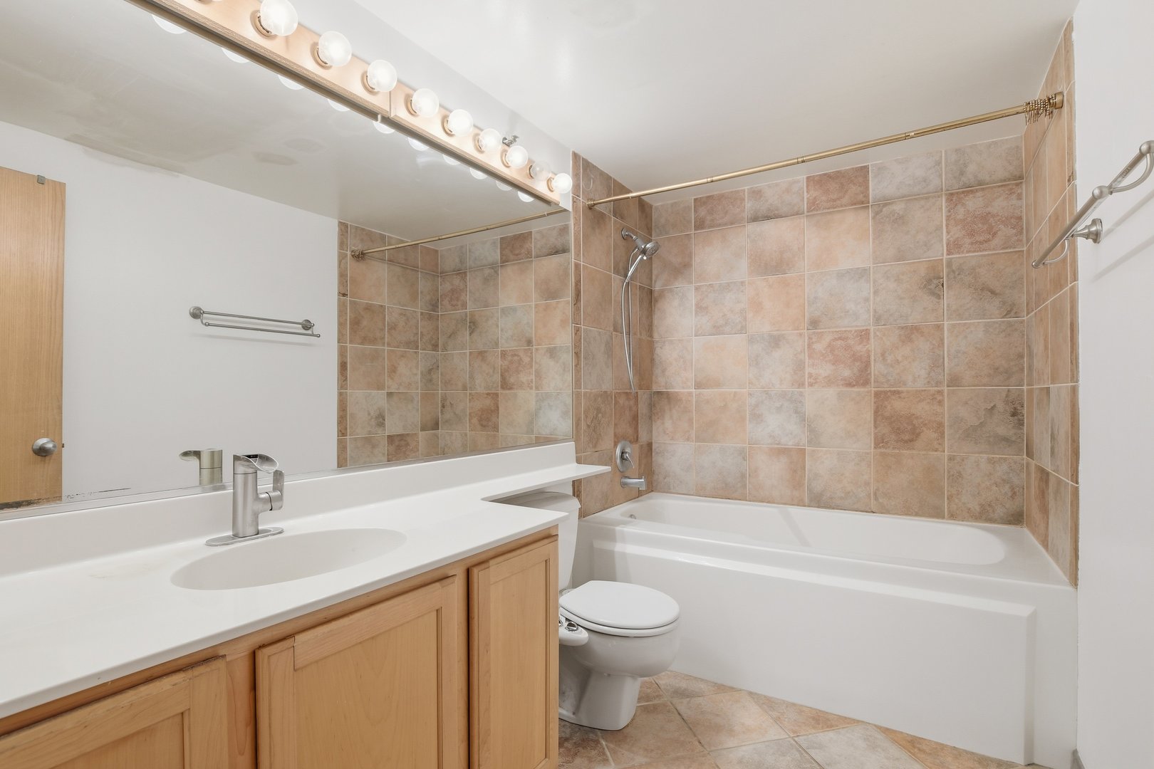 1250 West Van Buren Street, Unit 313 Chicago, IL 60607 - Photo 10 of 16 a bathroom with a sink a toilet and shower