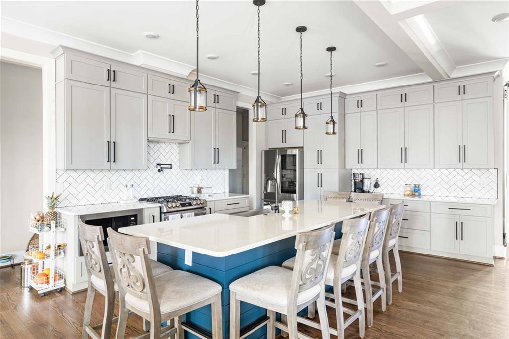 5758 Williams Road Norcross, GA 30093 - Photo 16 of 90 a kitchen with stainless steel appliances kitchen island granite countertop a dining table chairs and white cabinets