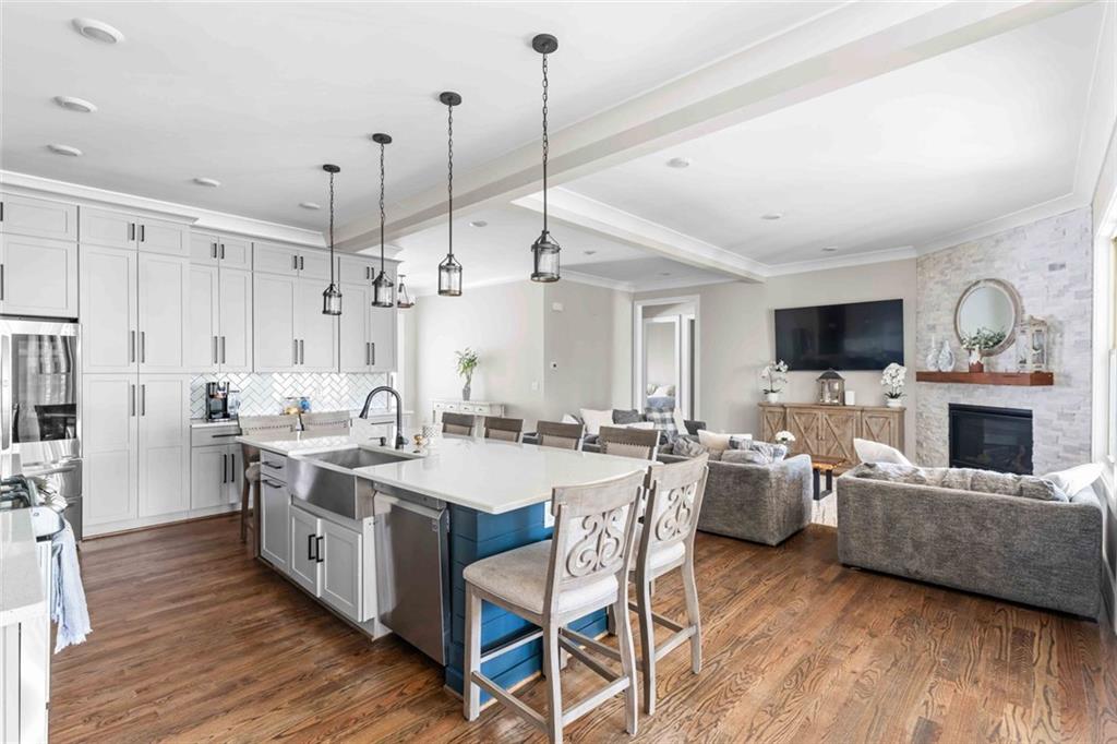 5758 Williams Road Norcross, GA 30093 - Photo 17 of 90 a large kitchen with stainless steel appliances kitchen island granite countertop a stove a sink dishwasher a dining table and chairs with wooden floor