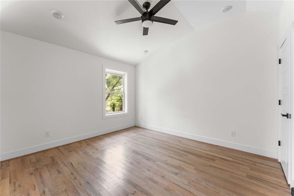 5758 Williams Road Norcross, GA 30093 - Photo 69 of 90 an empty room with wooden floor a ceiling fan and windows