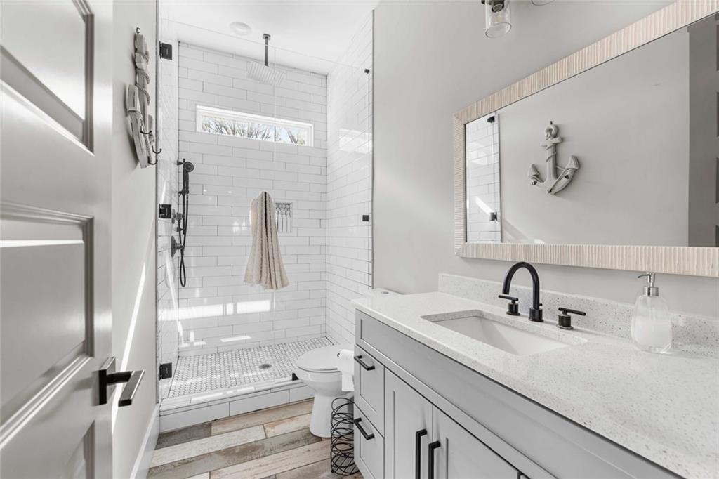 5758 Williams Road Norcross, GA 30093 - Photo 70 of 90 a bathroom with a sink a mirror and a shower