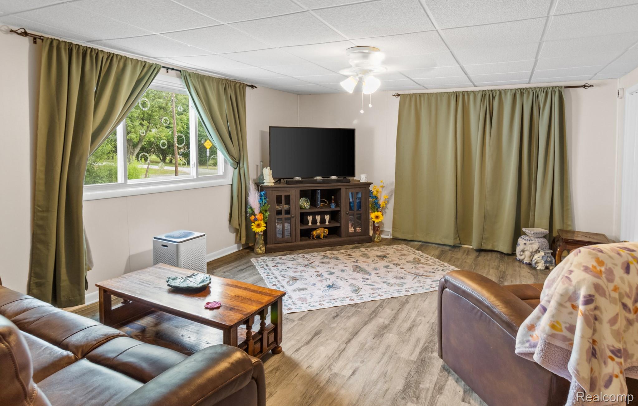 7330 Embury Road Grand Blanc, MI 48439 - Photo 15 of 29 Living area featuring wood-finish flooring, a white drop-panel ceiling, and recessed window with a verdant exterior