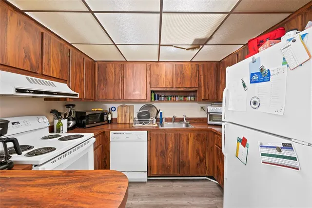 a kitchen with stainless steel appliances granite countertop a refrigerator and a stove top oven