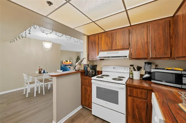 a kitchen with a stove cabinets and chairs
