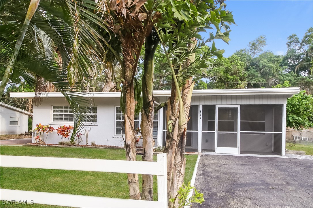 315 Ginger Road Venice, FL 34293 - Photo 1 of 16 a view of a house with a large window and a large tree