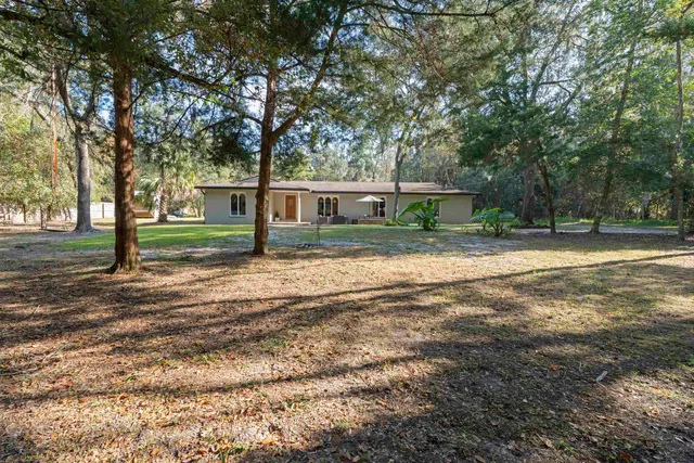 a backyard of a house with sofas fire pit and outdoor seating