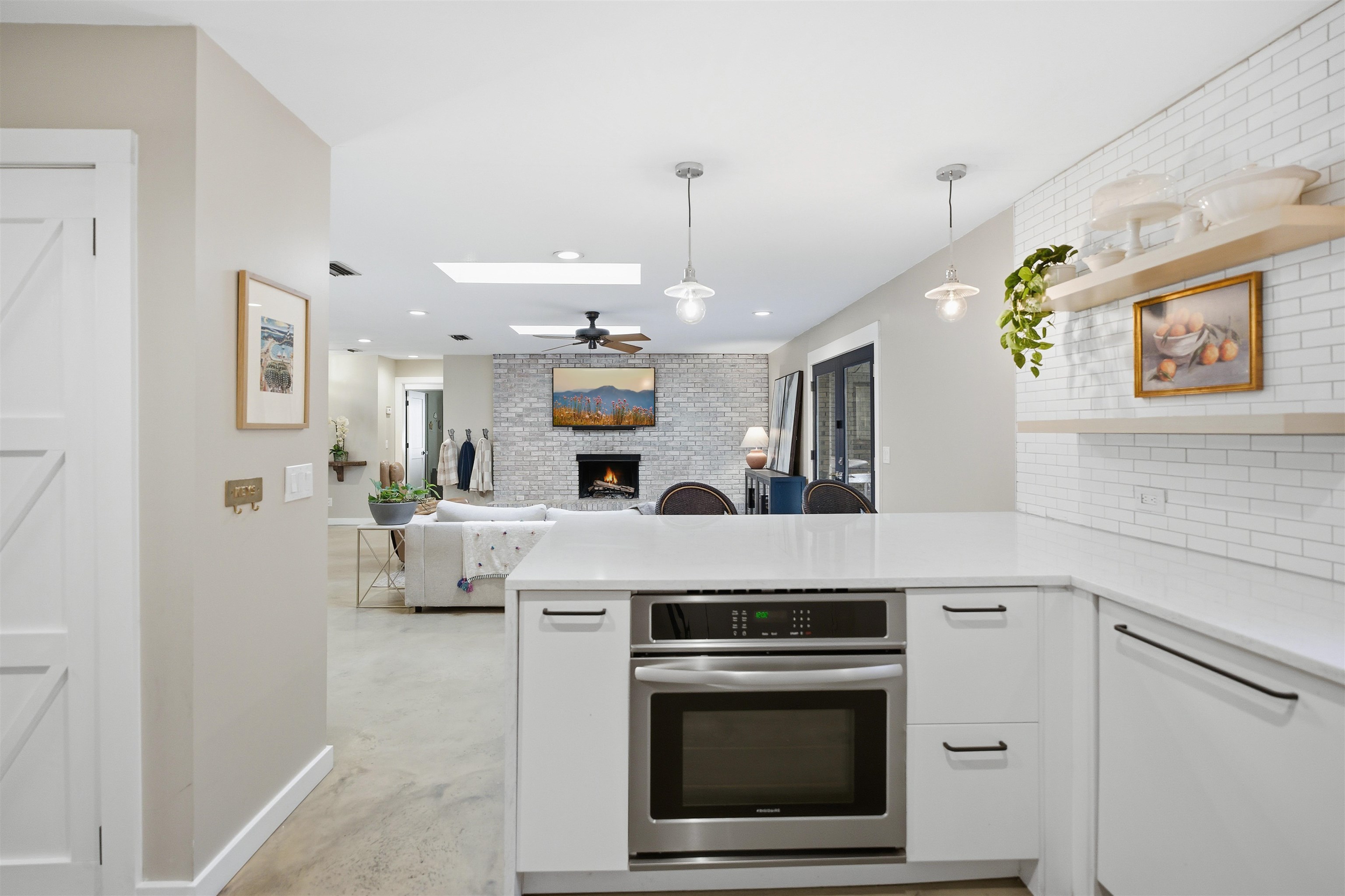 3572 Red Cloud Trail St. Augustine, FL 32086 - Photo 21 of 74 Kitchen featuring a peninsula, a brick fireplace, hanging light fixtures, oven, and a skylight