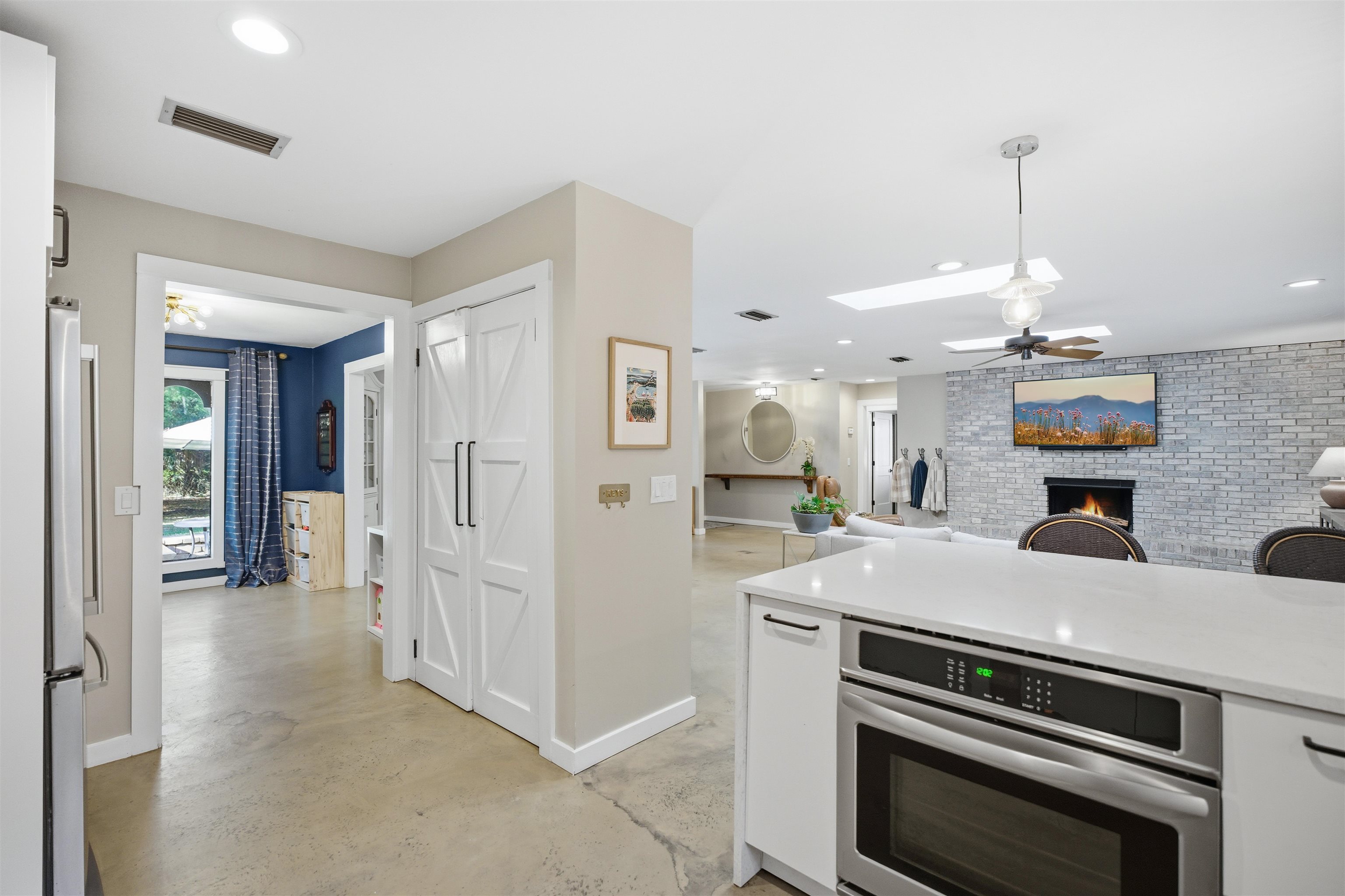 3572 Red Cloud Trail St. Augustine, FL 32086 - Photo 22 of 74 Kitchen with white cabinets, a fireplace, appliances with stainless steel finishes, concrete flooring, and recessed lighting