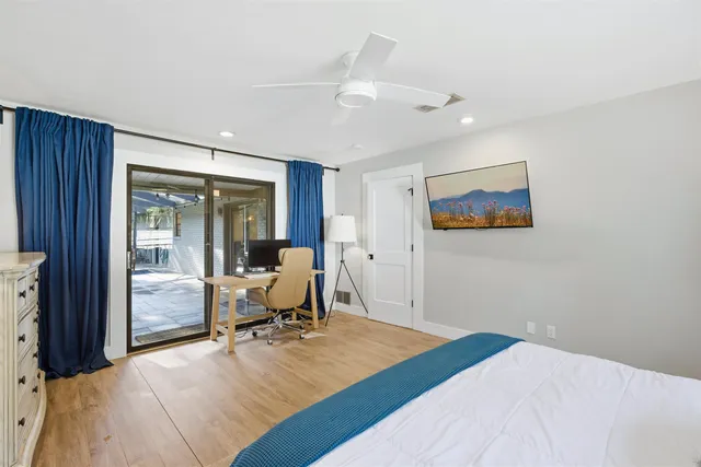 a view of a patio with couches and table and chairs under an umbrella