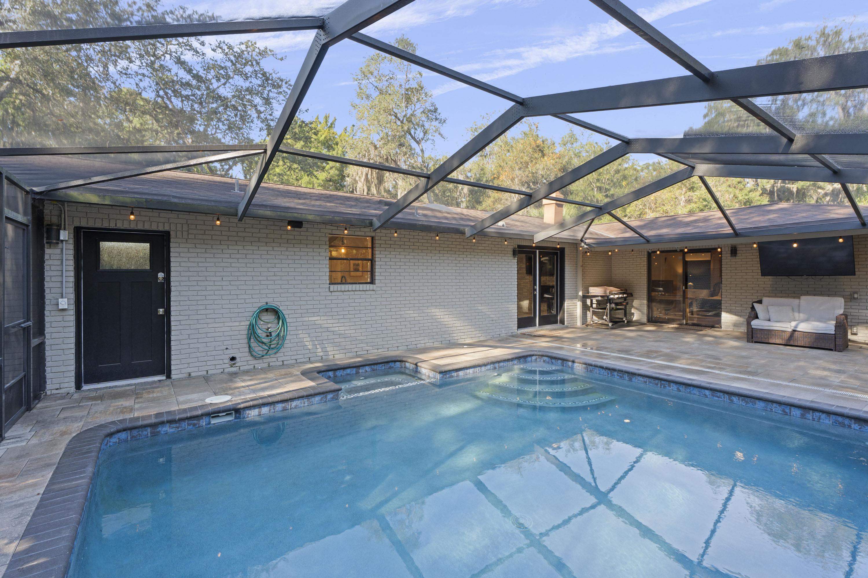 3572 Red Cloud Trail St. Augustine, FL 32086 - Photo 44 of 74 View of swimming pool with glass enclosure, a patio, a sunroom, and a pool with connected hot tub