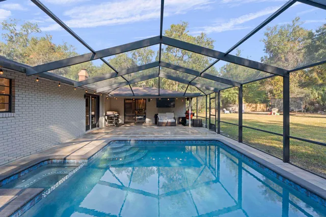 an aerial view of a house with yard and swimming pool
