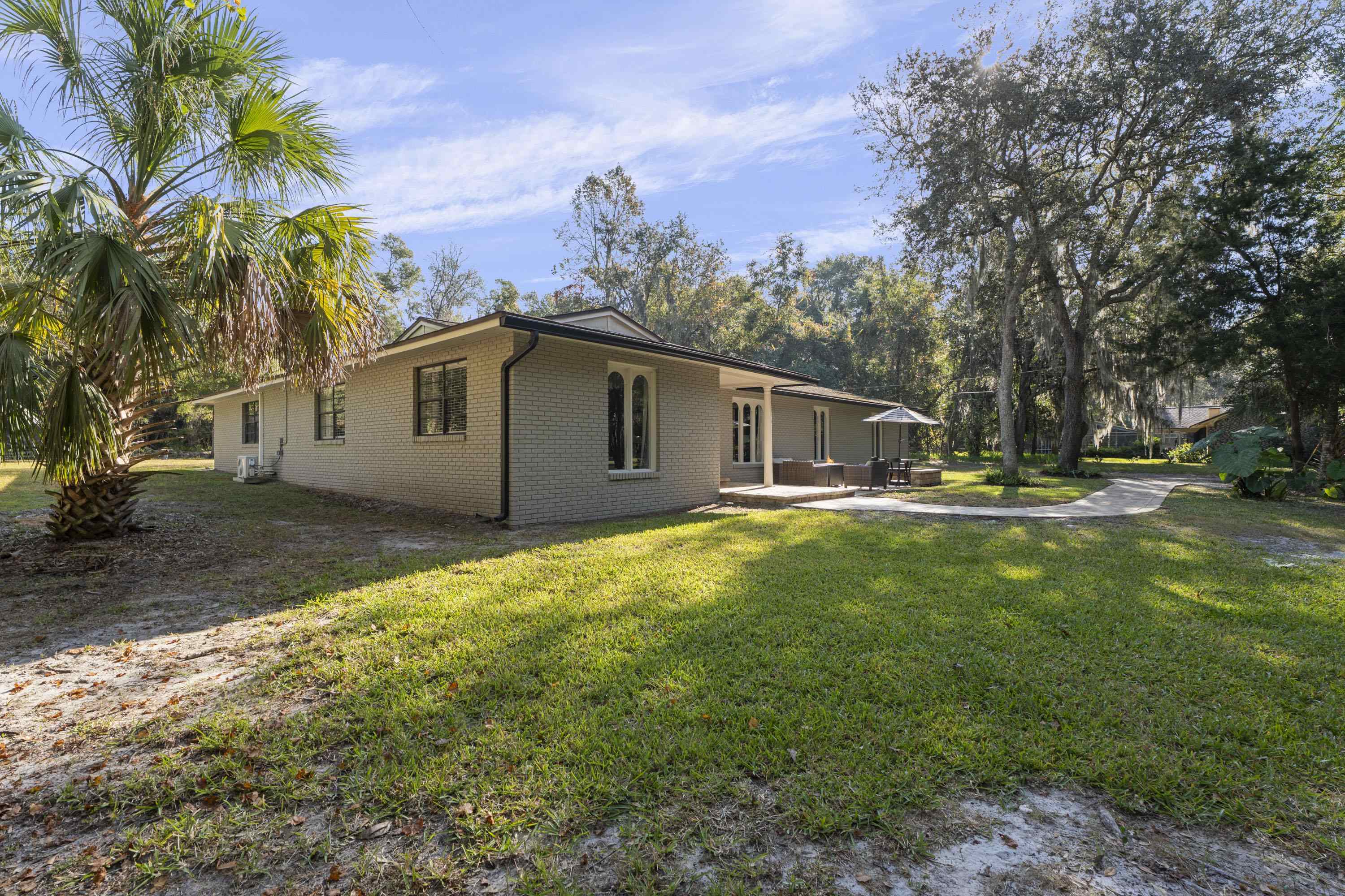 3572 Red Cloud Trail St. Augustine, FL 32086 - Photo 57 of 74 View of side of property with brick siding, a yard, and a patio