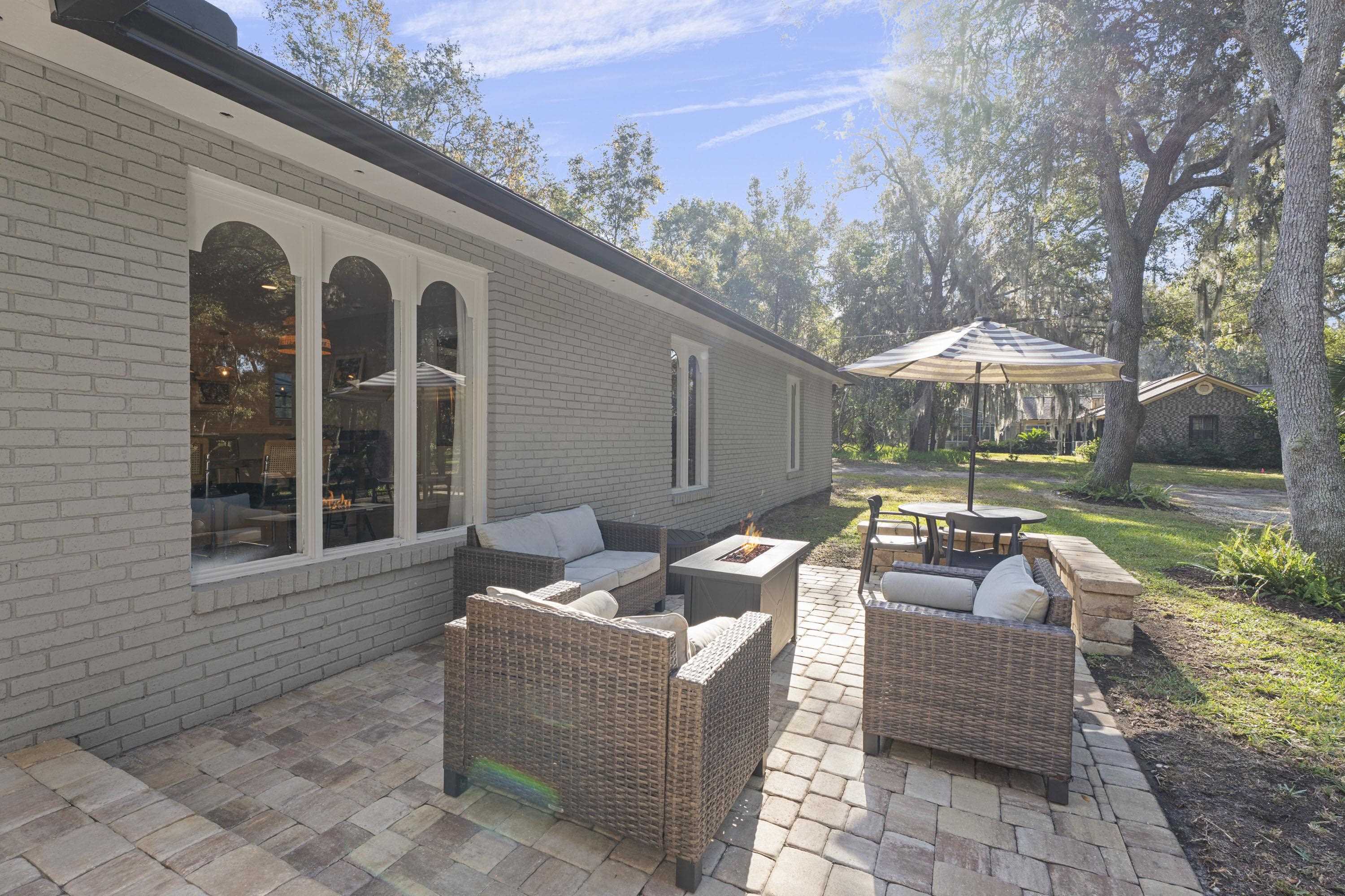 3572 Red Cloud Trail St. Augustine, FL 32086 - Photo 59 of 74 a view of a patio with couches and table and chairs under an umbrella